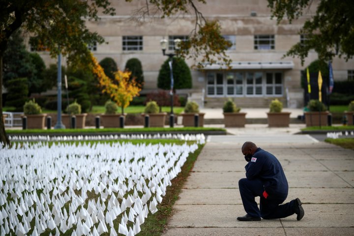 In pictures: A person kneels down in front of the art installation 'IN AMERICA How Could This Happen...' by artist Suzanne Brennan Firstenberg, as the spread of the coronavirus disease (COVID-19) continues, on the DC Armory Parade Ground, in Washington D.C., U.S., October 23, 2020. (REUTERS/Hannah McKay)