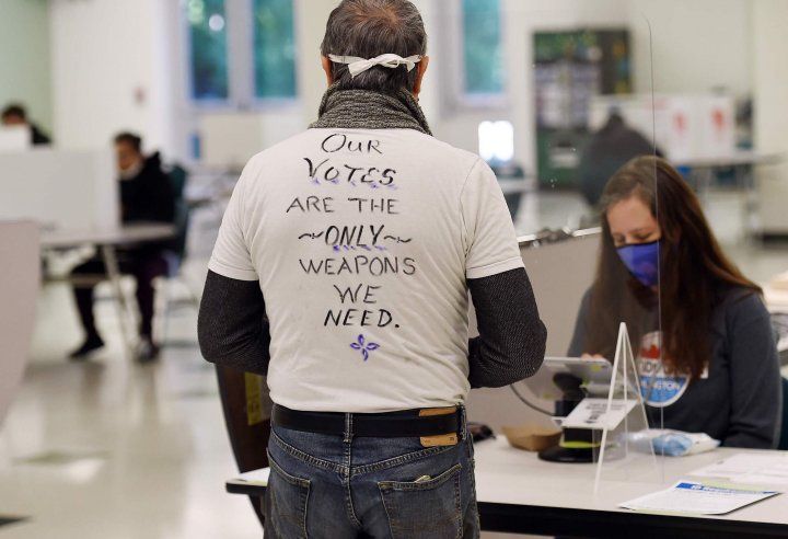 	A voter wears a hand-written message as he arrives to casts his ballot at a polling station on election day in Arlington, Virginia