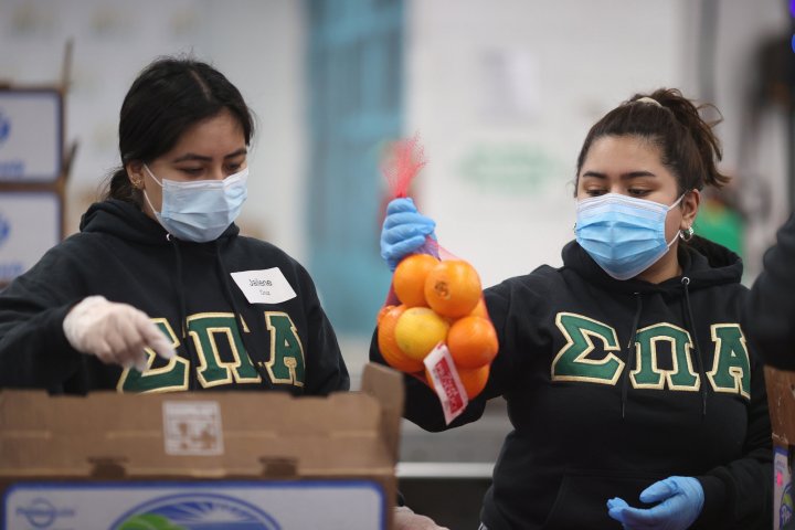 Volunteers Jailene Cruz and Genesis Maldonado sort food at the Los Angeles Regional Food Bank distribution center, as the global outbreak of the coronavirus disease (COVID-19) continues, in Los Angeles, California