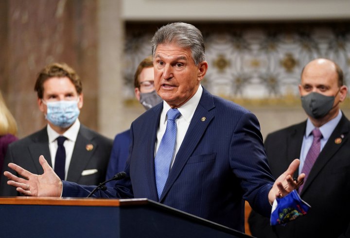U.S. Senator Joe Manchin (D-WVA) removes his mask to speak as bipartisan members of the Senate and House gather to announce a framework for fresh coronavirus disease (COVID-19) relief legislation at a news conference on Capitol Hill in Washington, U.S., December 1, 2020. REUTERS/Kevin Lamarque/File Photo