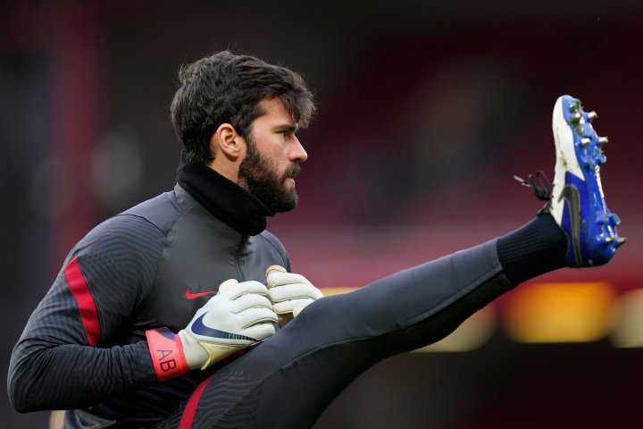 Liverpool's Brazilian goalkeeper Alisson Becker warms up ahead of the English Premier League football match between Liverpool and Manchester City at Anfield