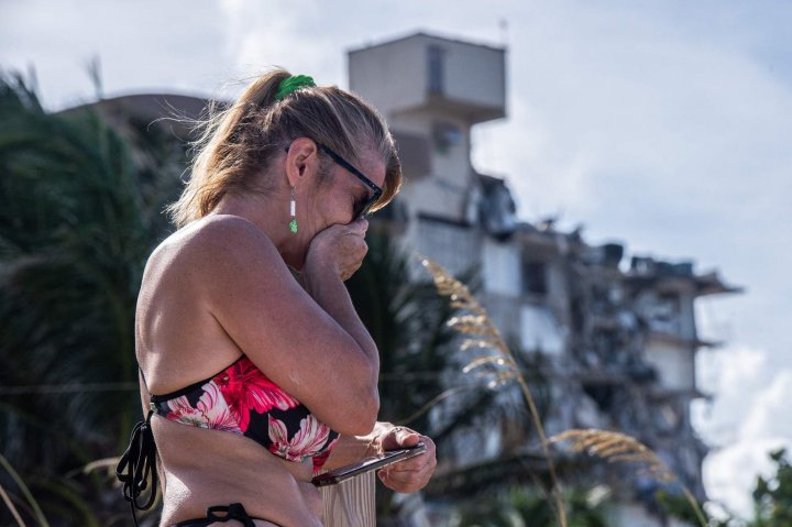 	A woman gets emotional on the seashore, as she approaches the nearby area of the partially collapsed 12-story Champlain Towers South condo building on June 27, 2021 in Surfside, Florida. Photo: AFP
