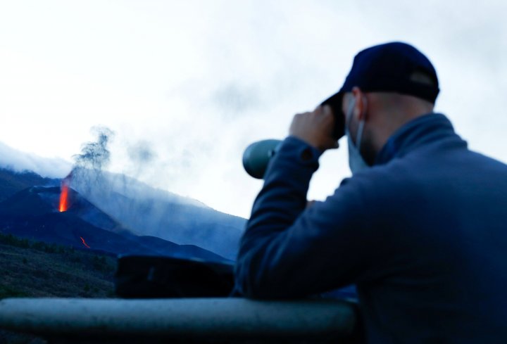 A man uses a spyglass from the Tajuya viewpoint to observe the Cumbre Vieja volcano, on the Canary Island of La Palma, Spain, October 26, 2021. REUTERS/Borja Suarez
