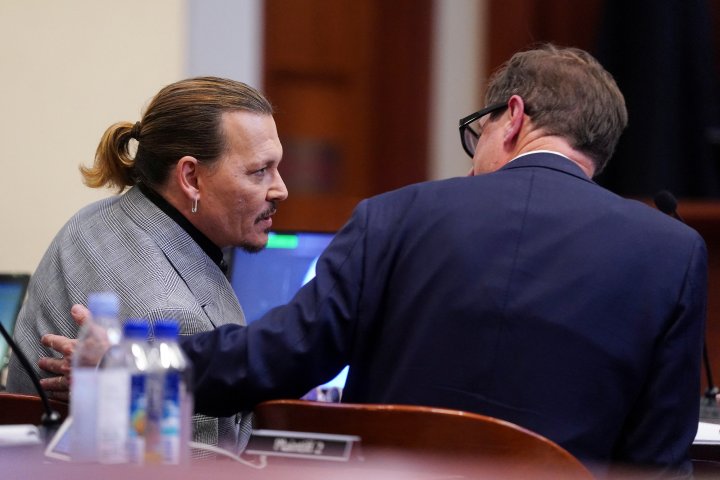 Actor Johnny Depp talks with his attorney Ben Chew during his defamation case against ex-wife, actor Amber Heard, at Fairfax County Circuit Court in Fairfax, Virginia, U.S., May 19, 2022. Shawn Thew/Pool via REUTERS