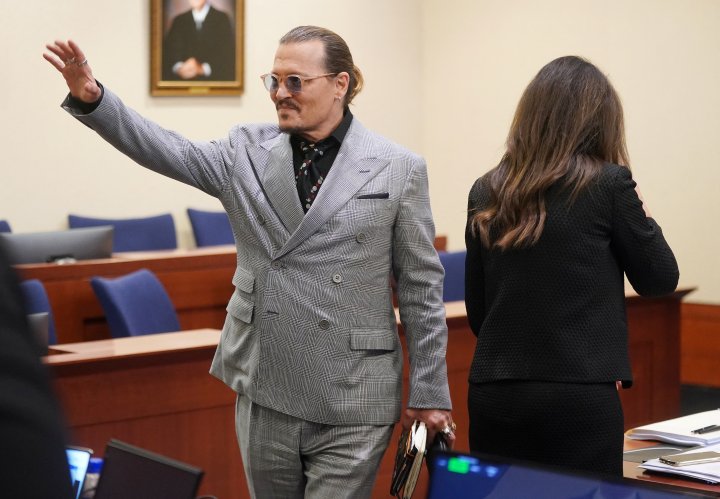 Actor Johnny Depp waves after returning from lunch break during his defamation case against ex-wife, actor Amber Heard at Fairfax County Circuit Court in Fairfax, Virginia, U.S., May 19, 2022. Shawn Thew/Pool via REUTERS