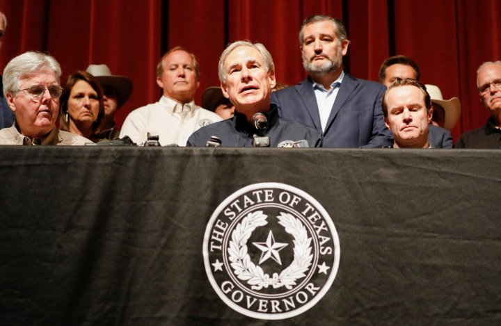 Texas Governor Gregg Abbott is accompanied by U.S. Senator Ted Cruz (R-TX) as he speaks to the media at Robb Elementary school, the day after a gunman killed 19 children and two teachers at the school in Uvalde, Texas, U.S. May 25, 2022. REUTERS/Marco Bello