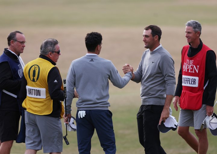 Golf - The 150th Open Championship - Old Course, St Andrews, Scotland, Britain - July 14, 2022 Scottie Scheffler of the U.S. shakes hands Chile's Joaquin Niemann after they finish their first round REUTERS/Russell Cheyne