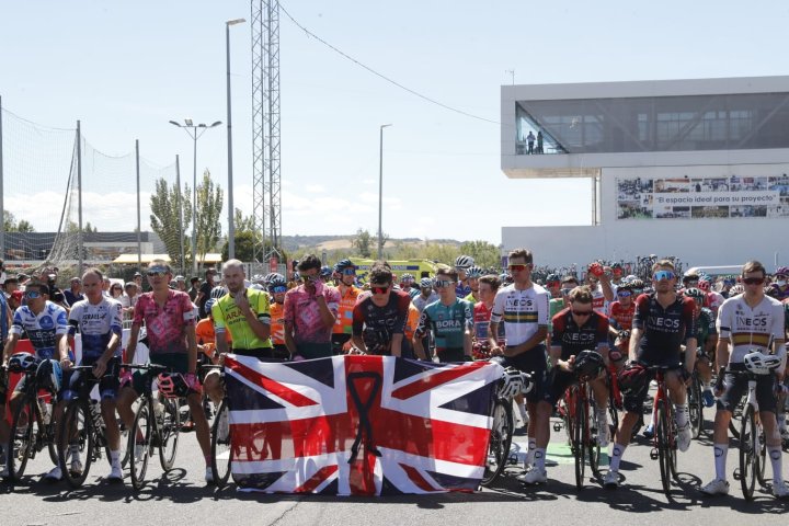 Los ciclistas británicos del pelotón de La Vuelta posan con la bandera británica y guardan un minuto de silencio por la muerte de Isabel II antes de la Etapa 19 de la Vuelta a España en Talavera de la Reina.