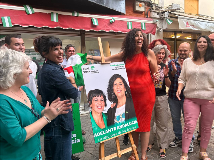Teresa Rodríguez (izquierda), presentando el cartel de Sandra Heredia (derecha), candidata a la alcaldía de Sevilla.