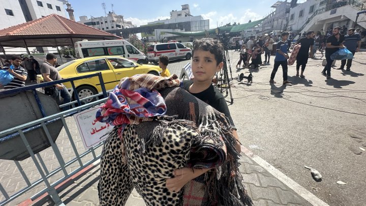 Un niño carga con sus pertenencias en dirección al sur de Gaza