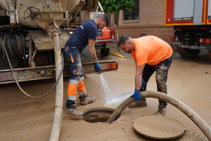 Jordi Guijarro, de naranja, trabaja en las labores de limpieza del alcantarillado. 