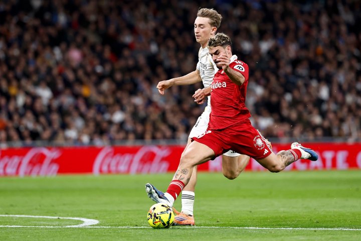 Huijsen y un jugador del Sevilla pelean por un balón.