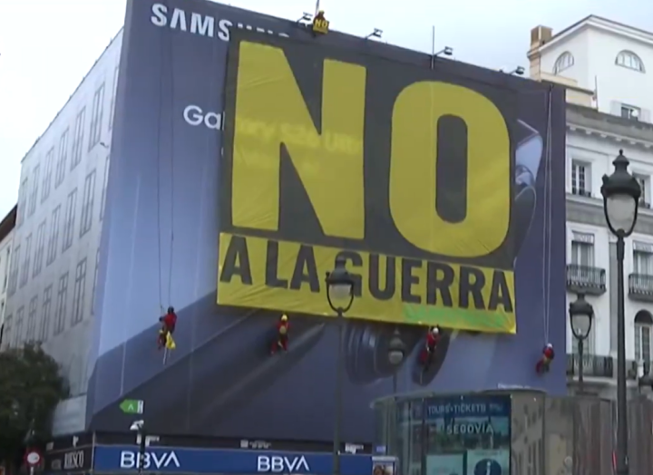 Greenpeace descuelga en la Puerta del Sol de Madrid una gran pancarta con un 'No a la guerra'